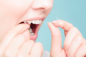 Oral hygiene and health care. Smiling women use dental floss white healthy teeth.