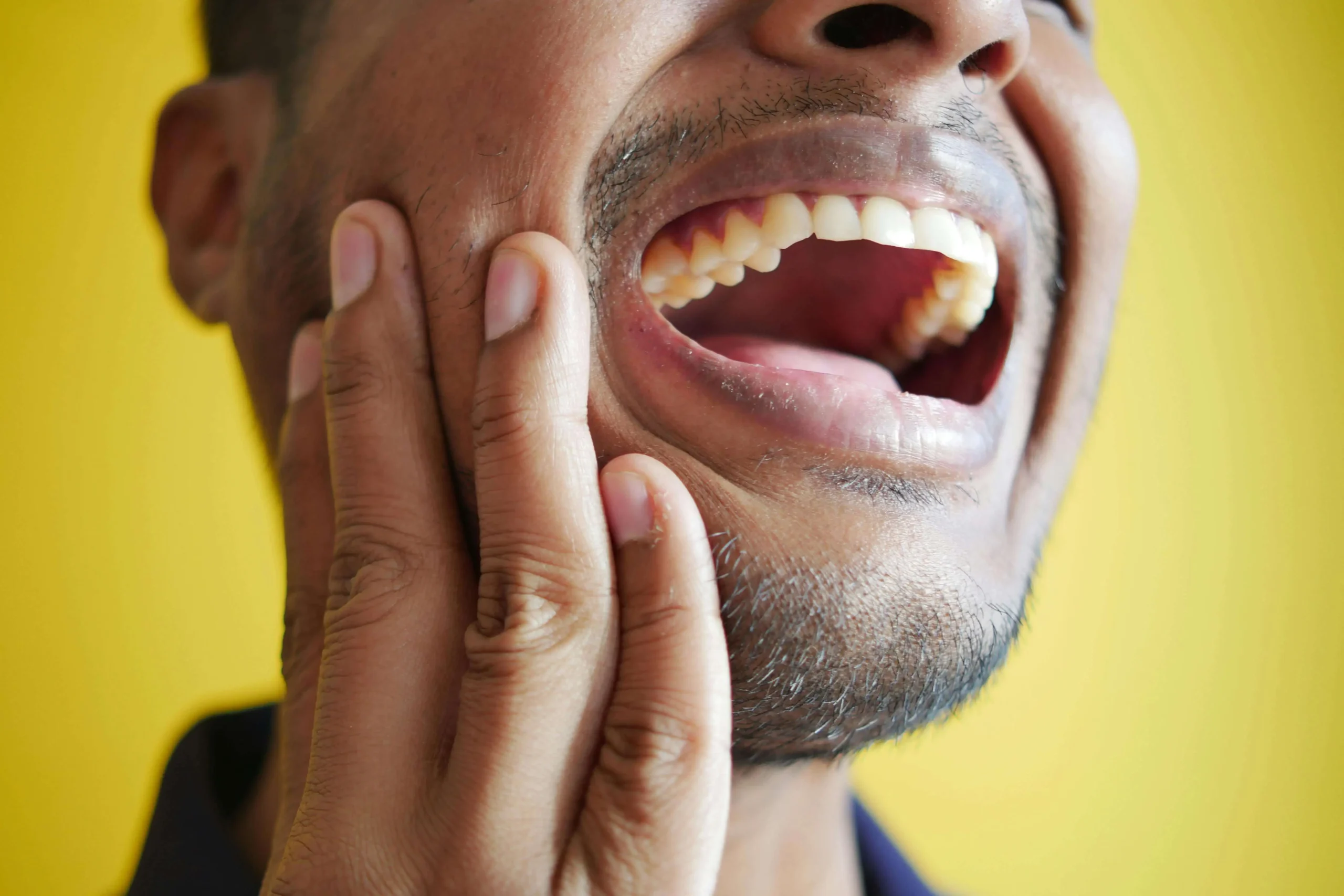 Why Is My Gum Swollen Around Just One Tooth Chinook Mall Family dental Calgary Man holding on to cheek with painful gums